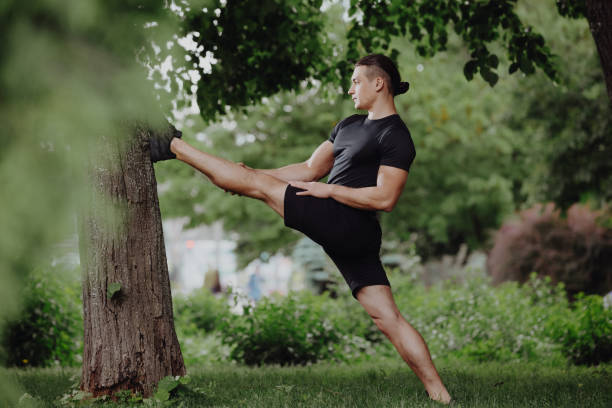 istock Sport fit man stretching legs near tree in park 1322316849