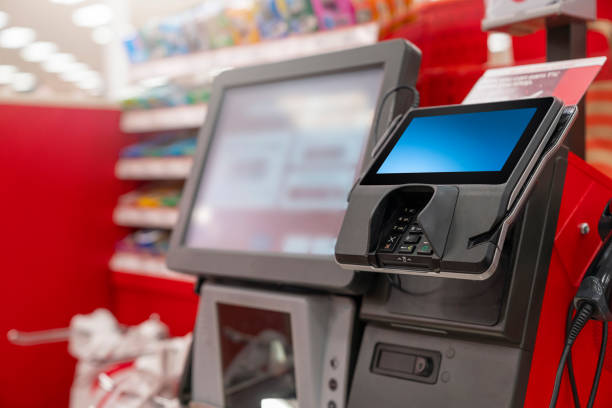 a pos machine at woolworths supermarket's self-serve checkout area with blur bokeh background - clothing store paying cashier credit card imagens e fotografias de stock