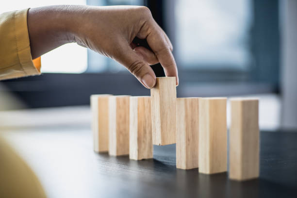 istock Businesswoman picking up a block of wood from a row, solving problems that arise during planned business operations, business problems caused by internal and external factors. 1322319185