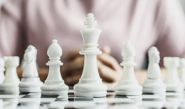 istock White chess pictures laid out on a chessboard, concept comparing playing chessboard to business administration. Businessmen playing chess are likened to business planning and problem-solving. 1322319358