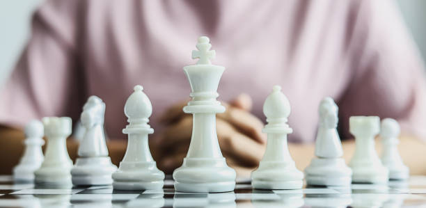 istock White chess pictures laid out on a chessboard, concept comparing playing chessboard to business administration. Businessmen playing chess are likened to business planning and problem-solving. 1322319932