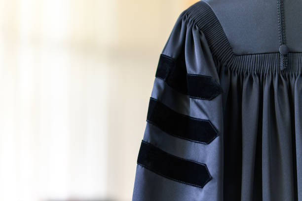 PhD graduate in black graduatio gown University degree PhD graduate in black graduatio gown University degree graduation clothing stock pictures, royalty-free photos & images