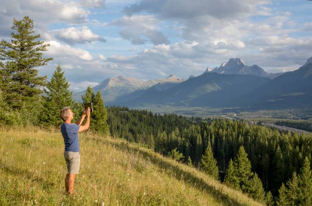 istock Man takes digital tablet snap of mountain view 1322320656