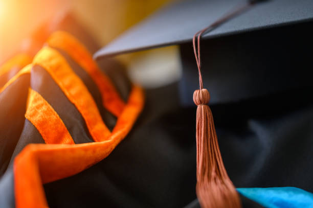 PhD graduate in black graduatio gown University degree PhD graduate in black graduatio gown University degree graduation phd stock pictures, royalty-free photos & images