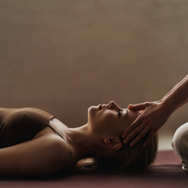 Young woman gets Thai head massage at spa salon. Warm inviting styling. Calm atmosphere. Copy space Young woman gets Thai head massage at spa salon. Warm inviting styling. Calm atmosphere. Copy space. Close-up relaxation lying on back women enjoyment stock pictures, royalty-free photos & images