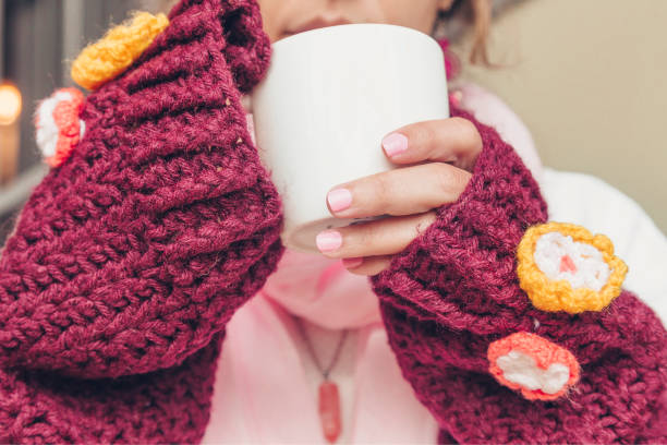 Woman's hands with white cup.