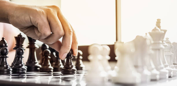 istock A businesswoman holding a black chess piece walks forward on a chessboard, comparing the chessboard to business administration, planning operations to achieve goals and solve business problems. 1322322201