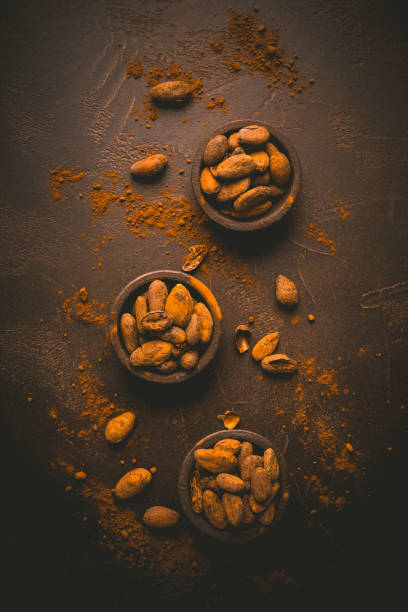 istock Organic cocoa beans in small bowls on brown background 1322322257