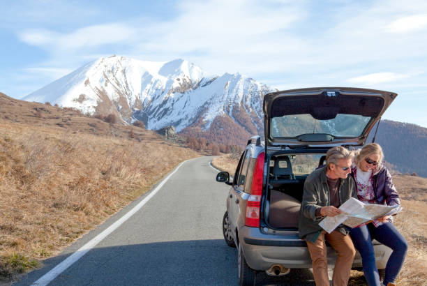 Couple pauses along mountain road to check direction