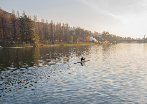 Man paddles kayak along Po River, Turin