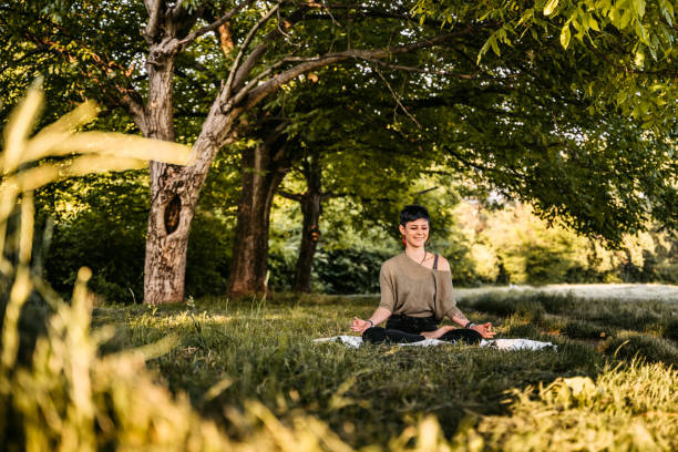 istock Young woman meditating in nature 1322326928