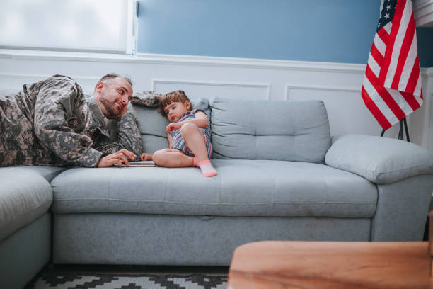 istock Happy father soldier and daughter using phone together 1322327398