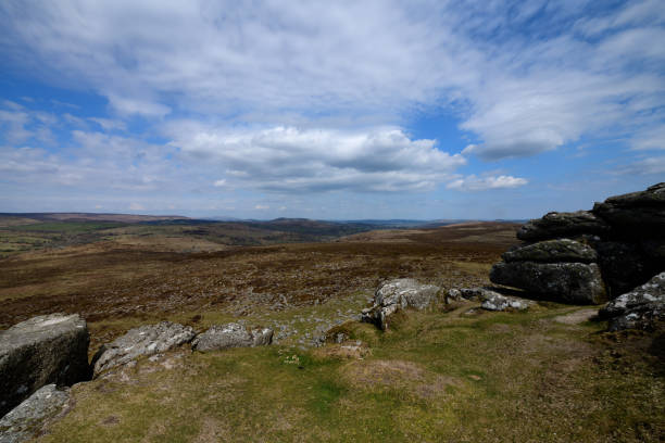 The photo is taken from Haytor and shows the moors of Dartmoor in the distance. \n Haytor which is a well-known rocky outcrop in the Dartmoor National Park. The granite outcrops in Dartmoor are known as ‘tors’\n\nDartmoor is situated in the south-west of the UK in an area often known as the West Country. It is a tourist destination. The photo was taken in April 2021.