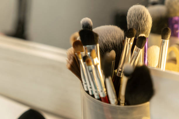 istock Many different makeup brushes stand on the makeup artist's desk in a round jar close-up, selective focus 1322334935