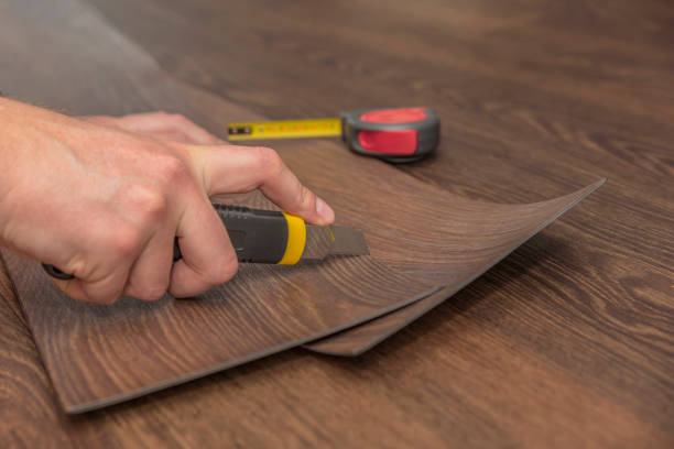 istock DIY vinyl flooring. Easy installation and cutting with a knife, Master cuts vinyl plank before installation, brown heated floor. Copy space 1322335885