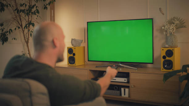 istock Screen time at home. Man relaxing while watching TV. Chroma key in the screen 1322336148