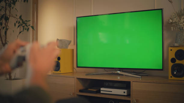 istock Screen time at home. Man relaxing while playing video games. Chroma key on the screen 1322336168