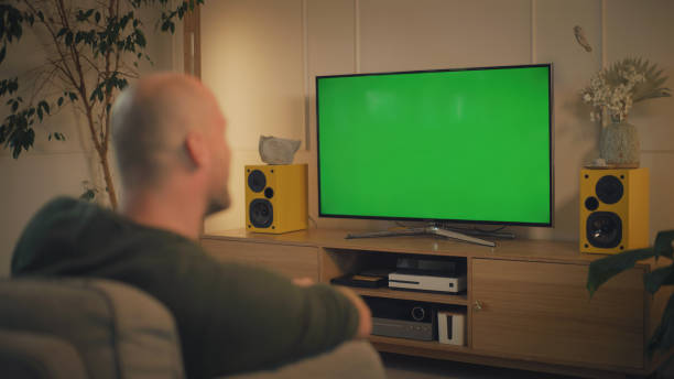 istock Screen time at home. Man relaxing while watching TV. Chroma key in the screen 1322336189