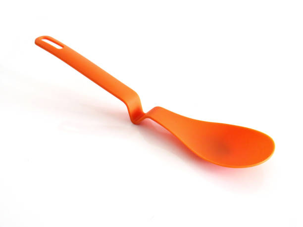 istock Close up of kitchen silicone spatula isolated. Stylish modern orange plastic spoon on white background. Accessories and Household Utensils. 1322340099