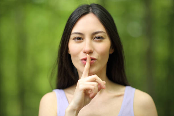 Asian woman asking for silence in a forest