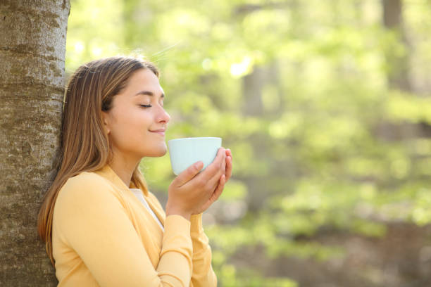 istock Woman smelling coffee in a forest or park 1322345380