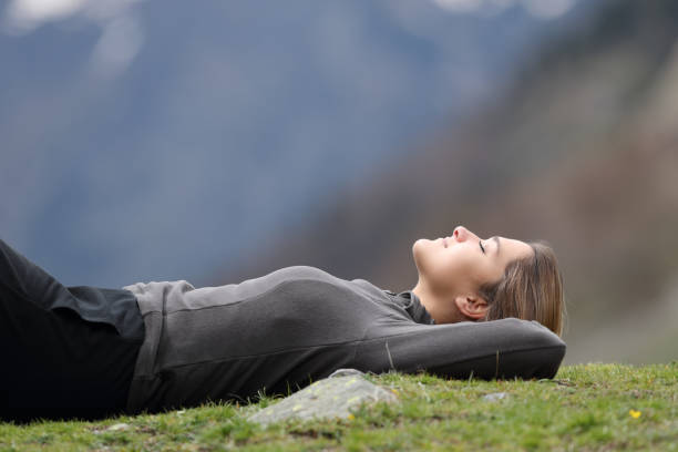 istock Trekker resting lying on the grass in the mountain 1322345445