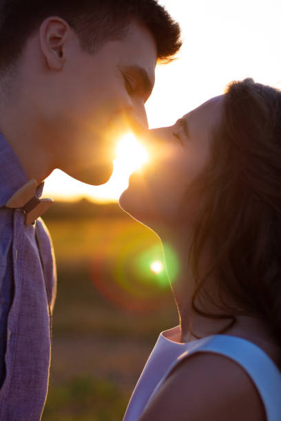 feliz pareja enamorada al atardecer - silhouette kissing park sunset fotografías e imágenes de stock