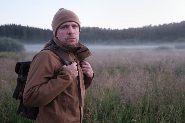 istock man walking through a field in summer at the evening. 1322349620