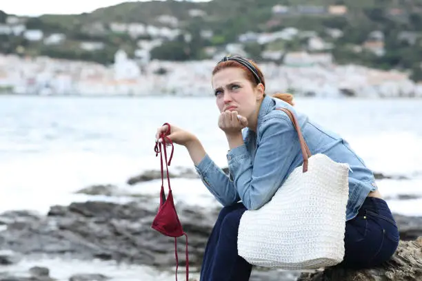 Photo of Frustrated tourist complaining on the beach due bad weather