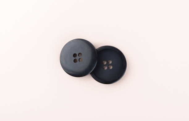 istock Top view of two sewing buttons on a light beige background. 1322351625