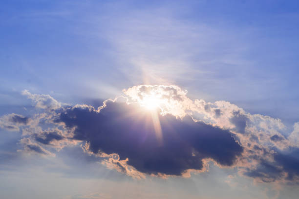 Photo of Blue Sky with Sun Peaking through Top of Clouds