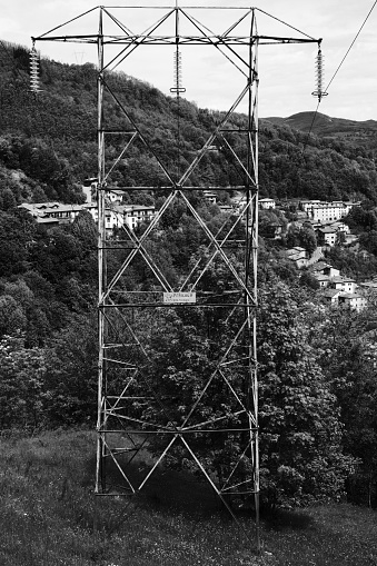 Fiumalbo, Italy, is a small lovely village on the mountains. Here, it is seen behind an old electricity pylon