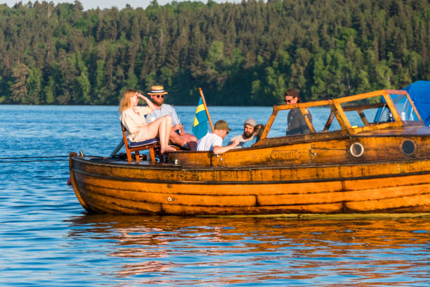 Stockholm, Sweden Stockholm, Sweden June 5, 2021 People sitting on the aft deck of a wooden boat anchored in lake Malaren lake malaren photos stock pictures, royalty-free photos & images