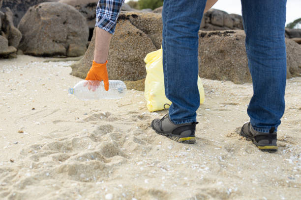 istock Man collecting a plastic bottle on the beach. 1322354393
