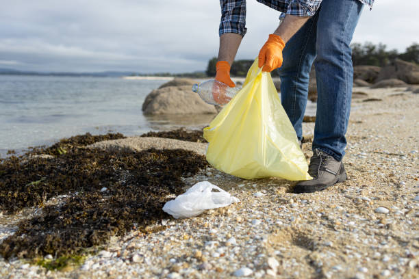 istock Man collecting a plastic bottle on the beach. 1322354421