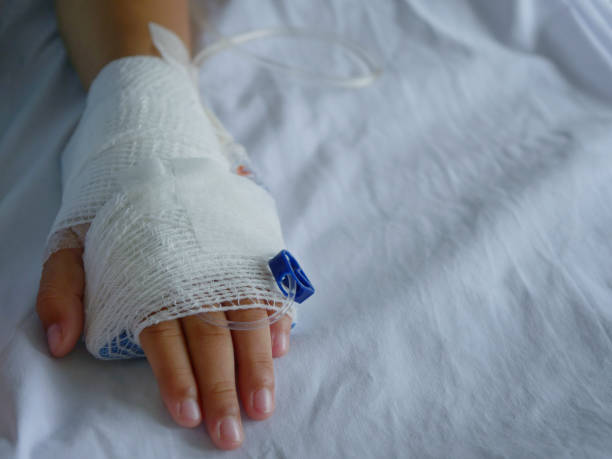 istock The patient's hand is wrapped in white bandages and has a saline line. 1322354519