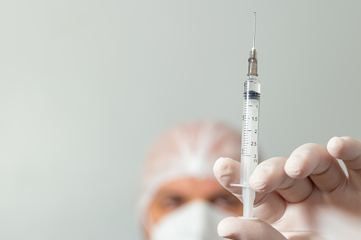 Médico sosteniendo jeringa con vacuna. photo