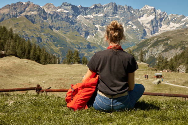 вид со спины молодой женщины, путешествующей в горах. - hiking young women outdoors t shirt стоковые фото и изображения