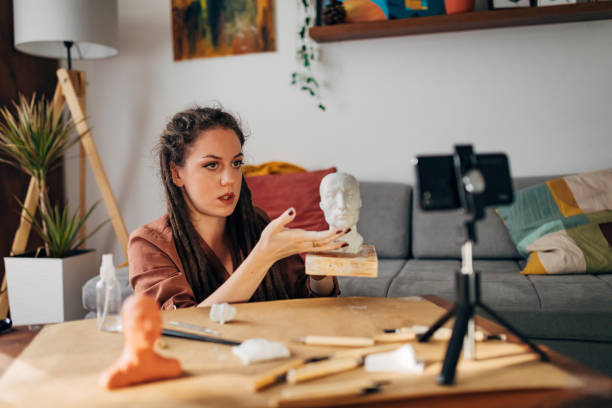 istock Craft woman explaining how to properly define anatomical structures on the face, during clay sculpting, while recording a tutorial for her DIY channel 1322357889