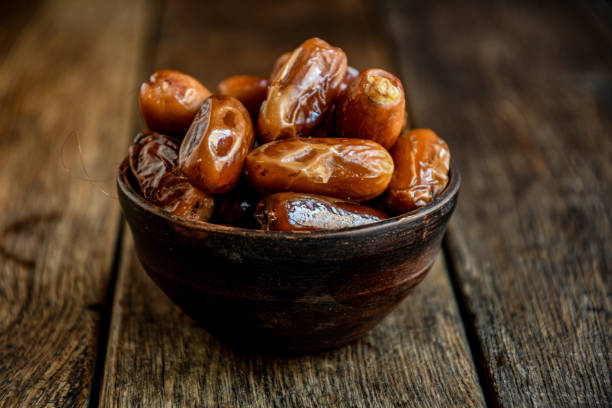 istock Dates in ceramic dishes on a wooden table. 1322358870