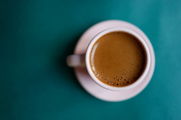 café turco com bastante espuma em um copo rosa em pó em um fundo verde turquesa escuro, fundo teal, close-up - latté cafe froth art cup - fotografias e filmes do acervo