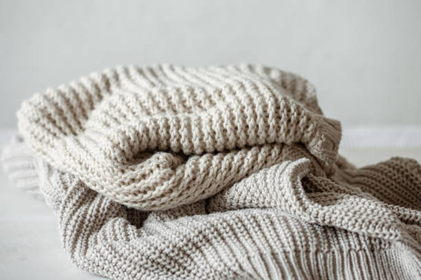 istock Cozy and warm knitted sweaters in pastel colors close-up. 1322358968