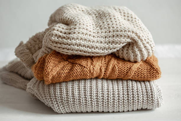 istock A stack of warm knitted sweathers on blurred background. 1322358983