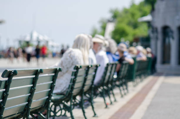 Row of benches with blurred people during nice day of springtime on the Dufferin Terrace downtown Quebec city.