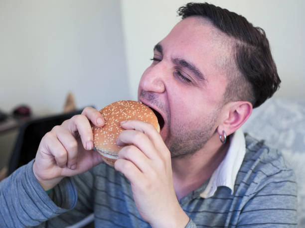 istock Hungry man biting fresh tasty hamburger 1322361198