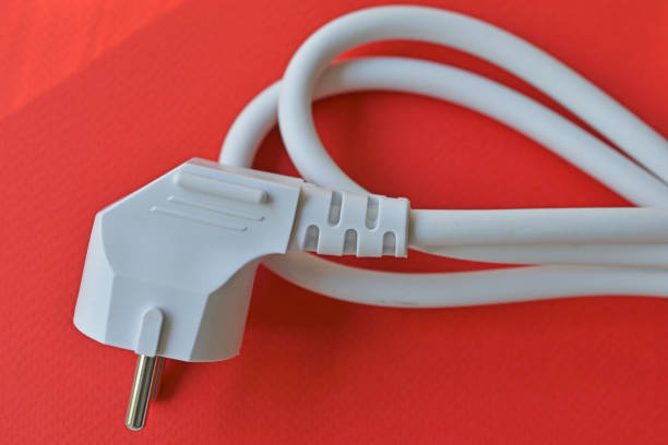 istock White electric euro plug on red background 1322361315