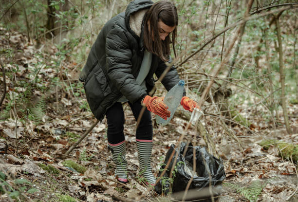 istock A girl with a trash bag cleans the environment from garbage. 1322363718