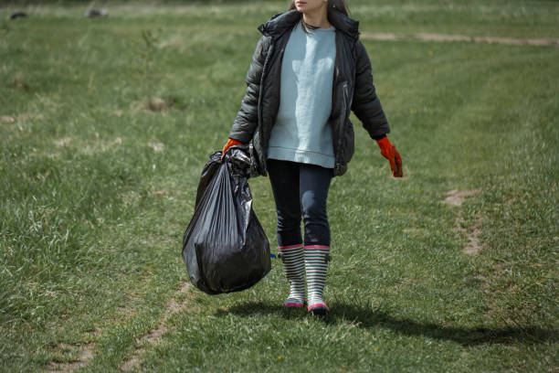 istock Girl volunteer with a trash bag in her hands. 1322363719