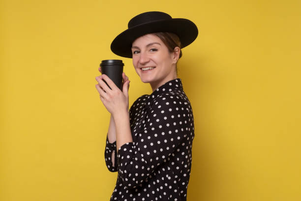 istock Caucasian woman in black hat holding coffee cup 1322365546
