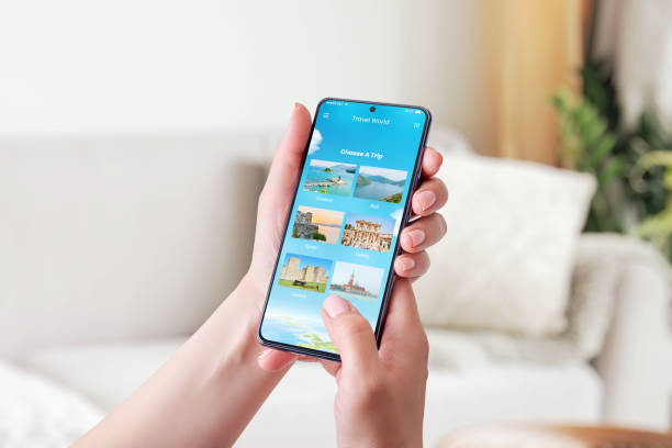 istock Choosing a travel destination with smart phone concept. Modern app with chose a trip option. Phone in woman hand. Close-up. 1322367294